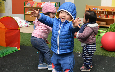 boy with arms outstretched at daycare