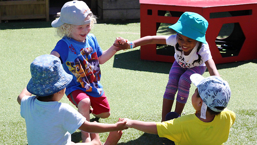 children hold hands in circle at daycare
