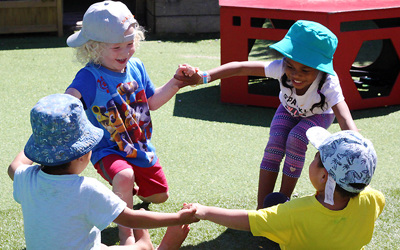 children hold hands in circle at daycare