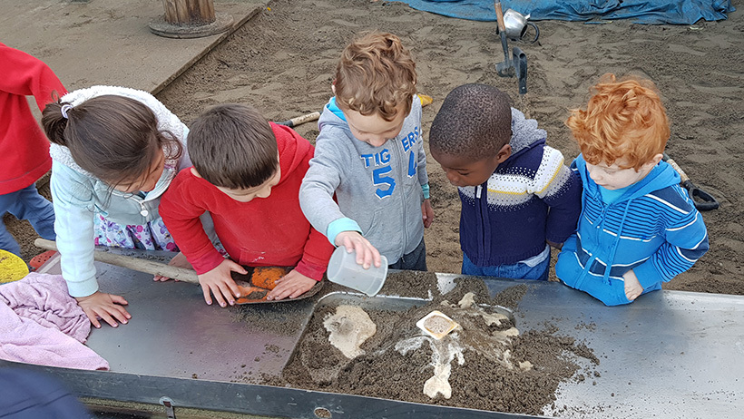 children playing with sand and water at preschool