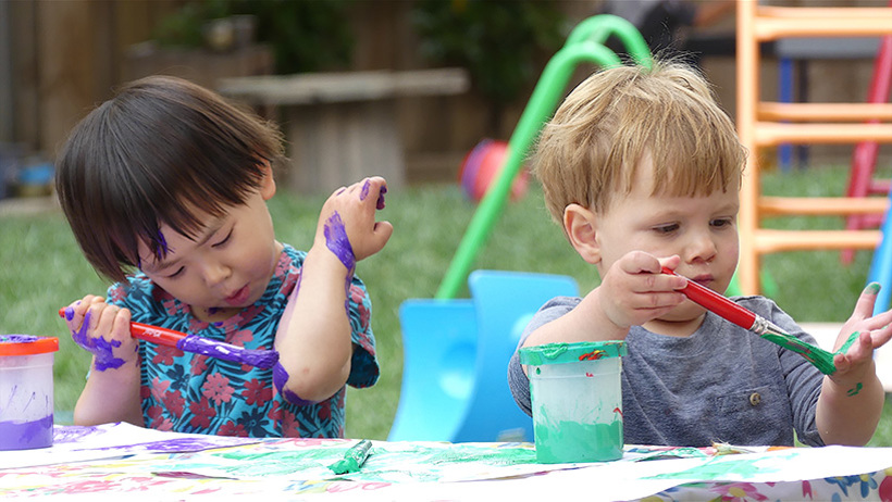 children painting hands at childcare