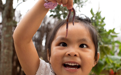 happy girl dangling worm at childcare
